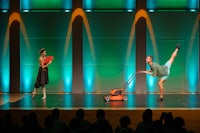 a man and a woman on stage with a lawn mower