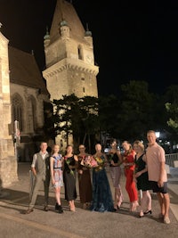 a group of people standing in front of a building at night